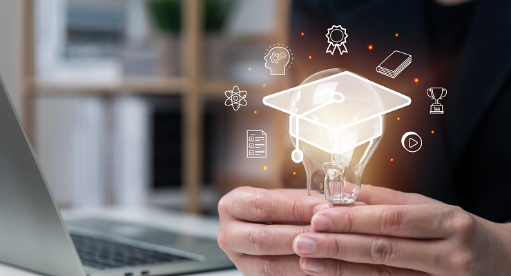 hands holding lightbulb with graduation cap