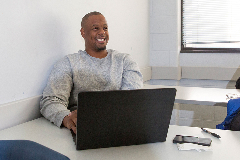 A male student logging into eCentennial on his laptop