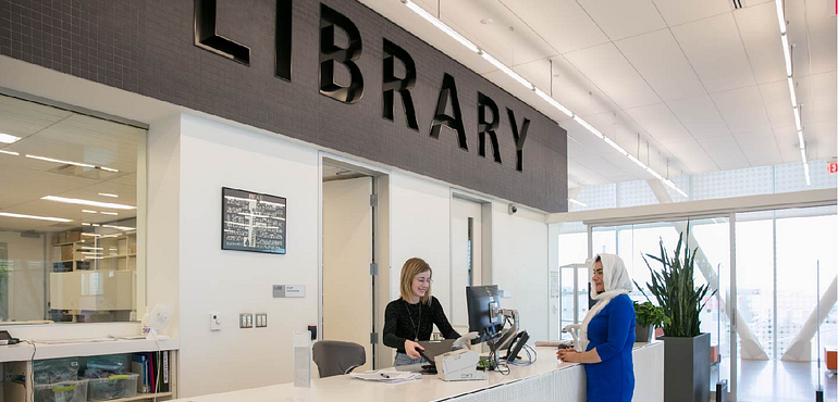 a student checks out a book from the library desk