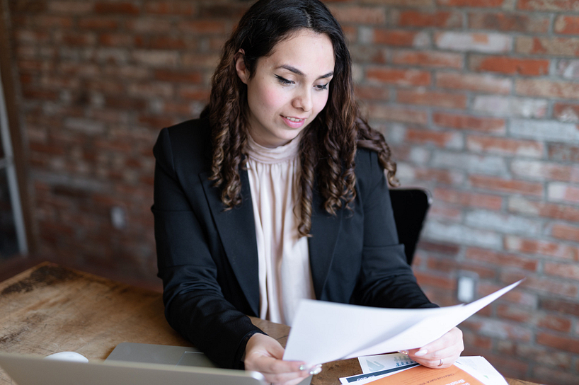 centennial college marketing management student reading a printed document while at a desk