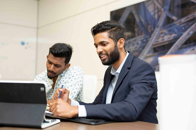 smiling centennial college student working on a tablet in an office