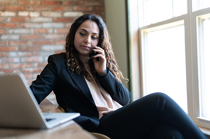 Female student making a serious phone call from her home desk