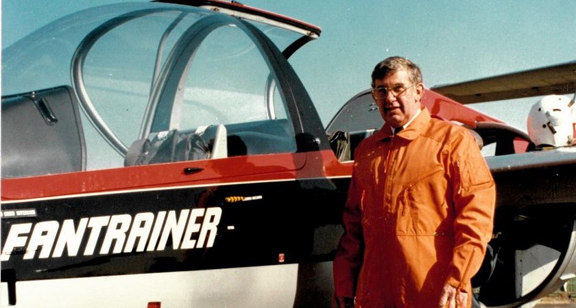 picture of bruce macrichie standing beside one of his airplanes