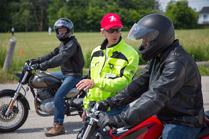 picture of a centennial college motorcycle rider training instructor teaching a student on a motorcycle