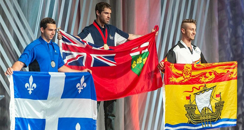 Ian Broomfield at the podium displaying the Gold medal