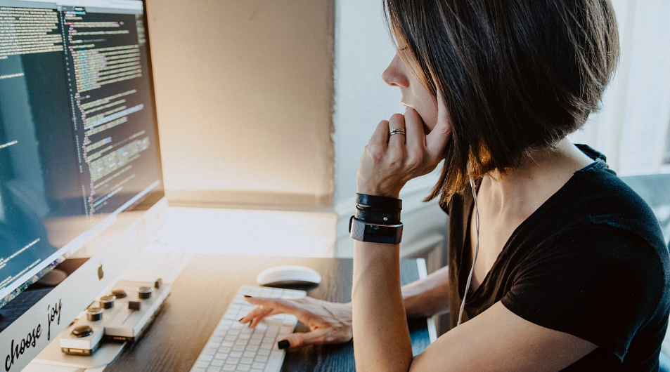 woman sitting at computer who may need the tech support chat service