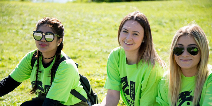 picture of Centennial College students sitting outside on grass smiling