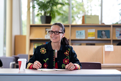 杰出奖获得者Margot Van Sluytman在故事艺术中心图书馆工作时面带微笑