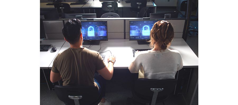 Two cybersecurity students at their computers