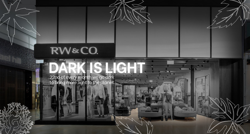 RW&CO store front in black and white with the caption dark is ligh 22nd of every month we go dark to bring more lightto the planet