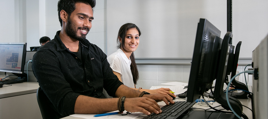two centennial college software engineering students working on computers in a lab
