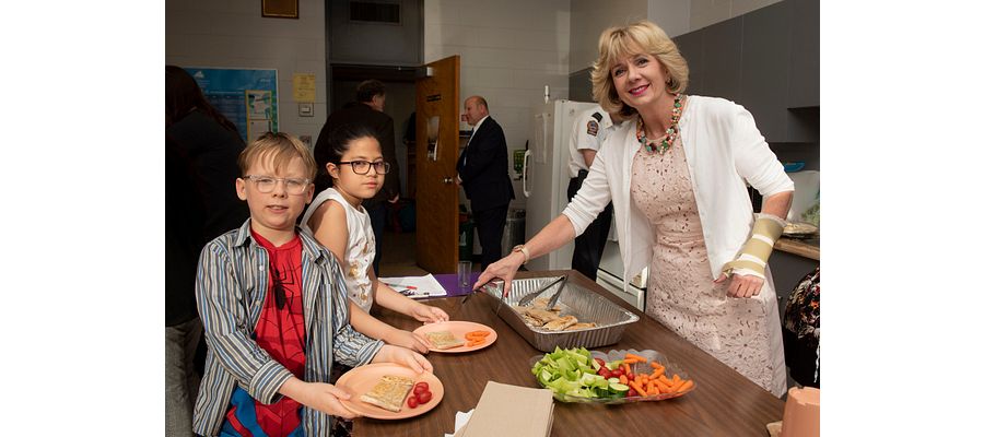 Ann Buller serving food to children at the breakfast club