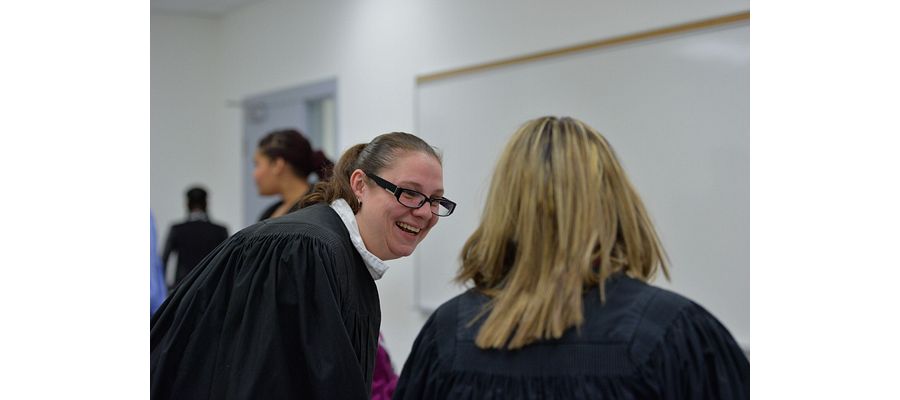 picture of a Centennial College Law Clerk program faculty member and student laughing in class during a mock trial