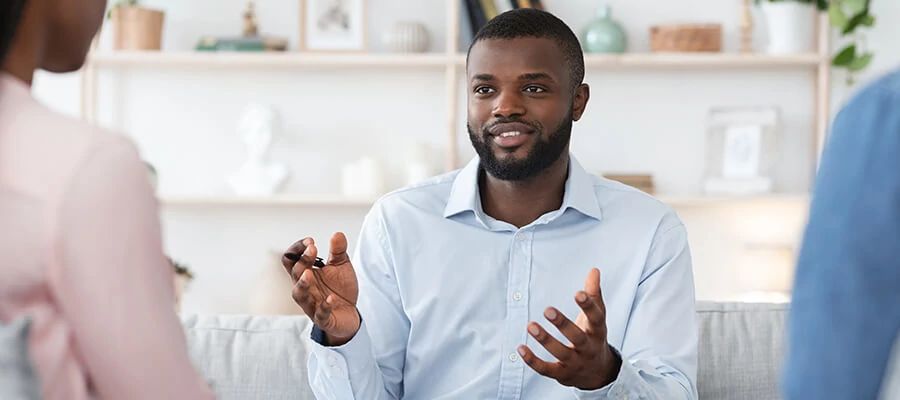 A photo of a professional student talking to two interviewers