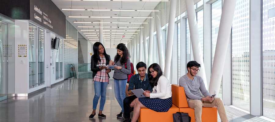 A Centennial College students sitting on a couch in the Ashtonbee Campus hallway