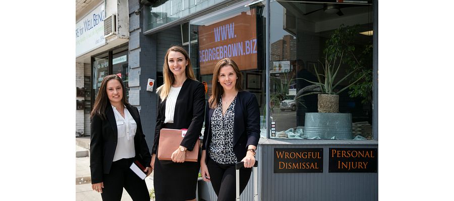 Centennial college graduates dressed in business professional outside a law office