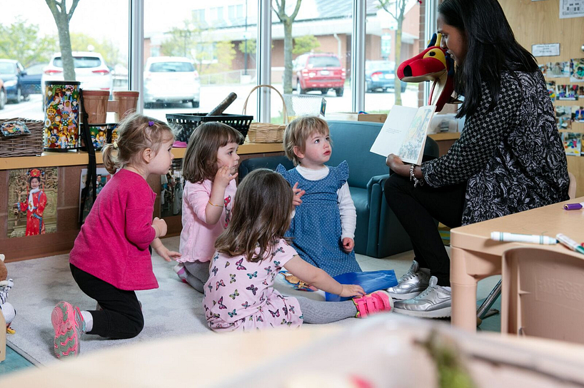Daycare kids and teacher reading a book