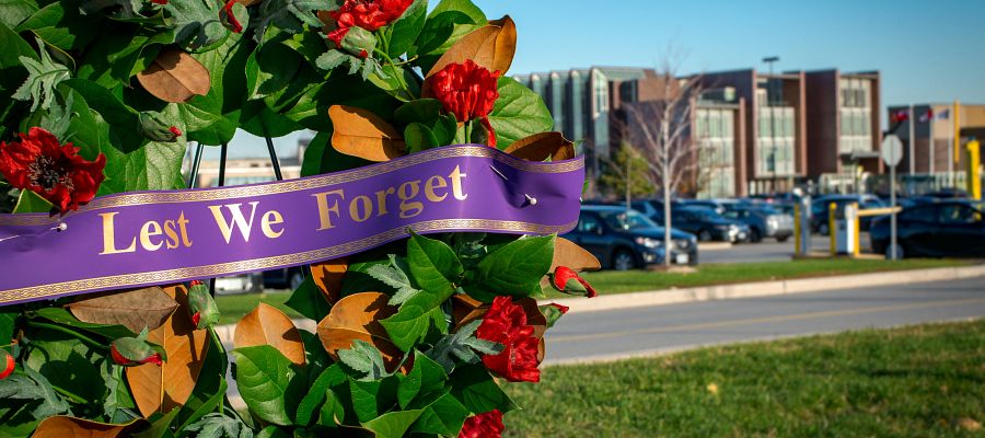 wreath outside progress campus with a ribbon that reads Lest We Forget