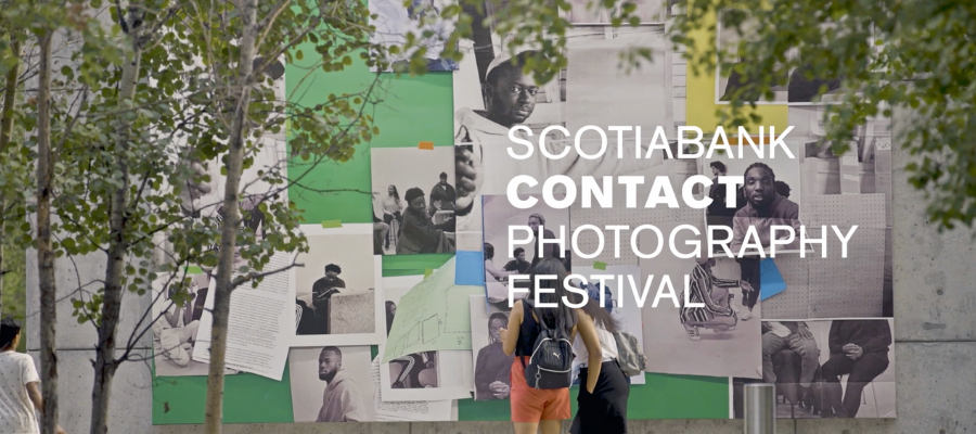 Two females standing beside a public photo wall at the ScotiaBank Contact Photography Festival