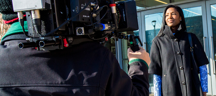 camera man holding a camera while filming a subject