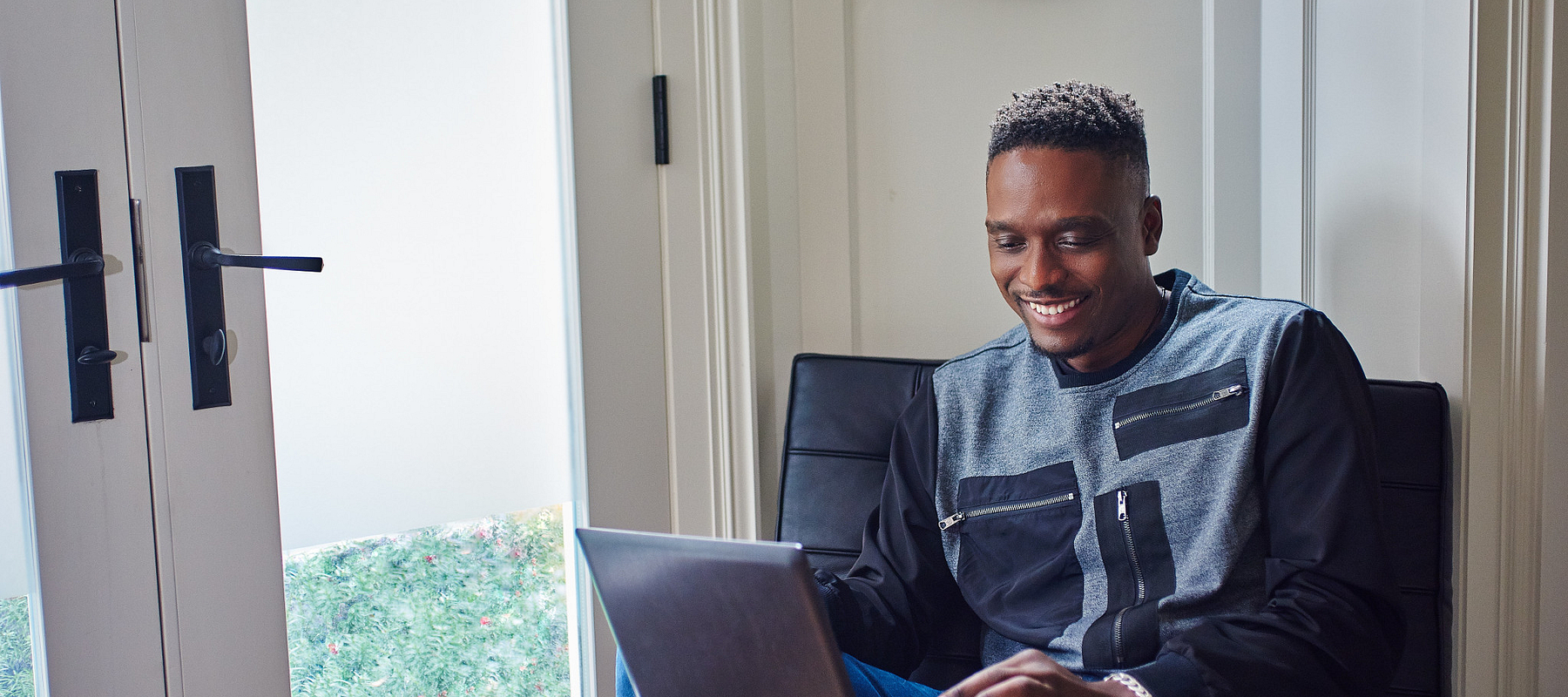 centennial college student smiling and learning to code on a laptop from home