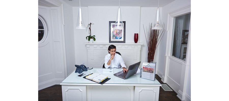 A male student studying on his laptop at a desk