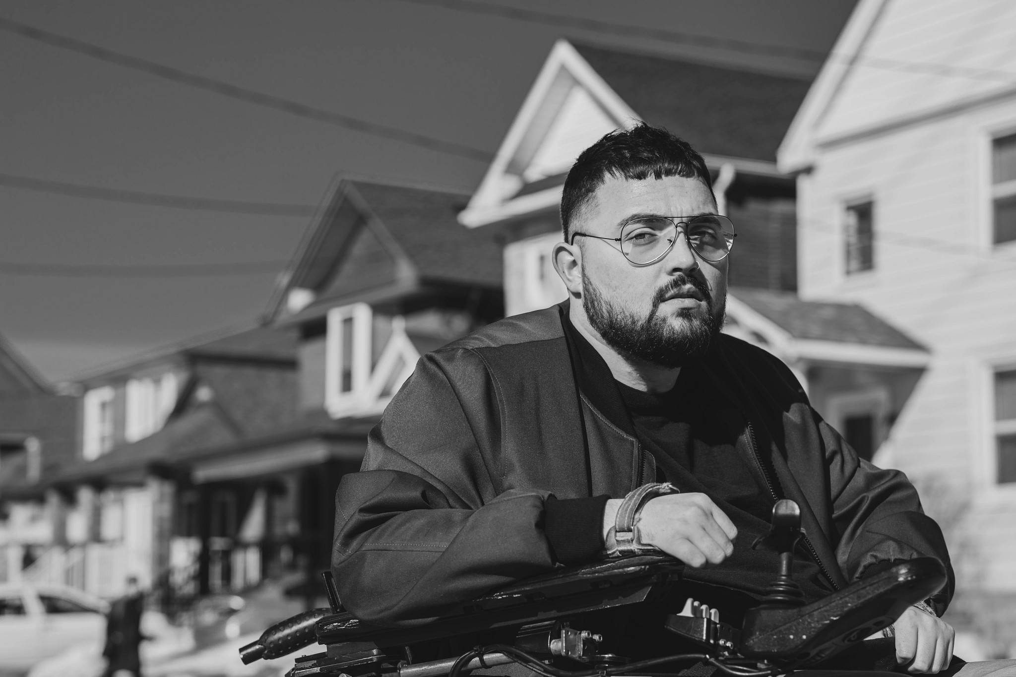 A young man sitting in a wheelchair while wearing IZ Adaptive clothing