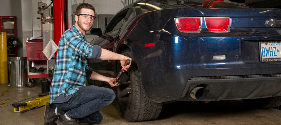 Picture of a male student working on car in the Chrysler/Fiat lab