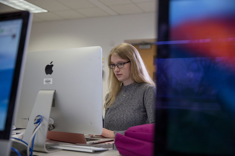 smiling student at a computer