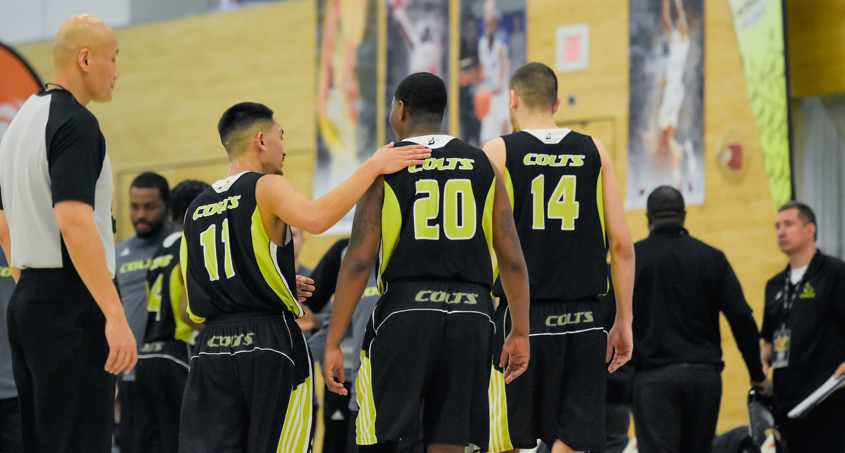centennial college basketball players patting each other on the back during a game