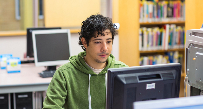 Male student sitting at a computer applying for OSAP