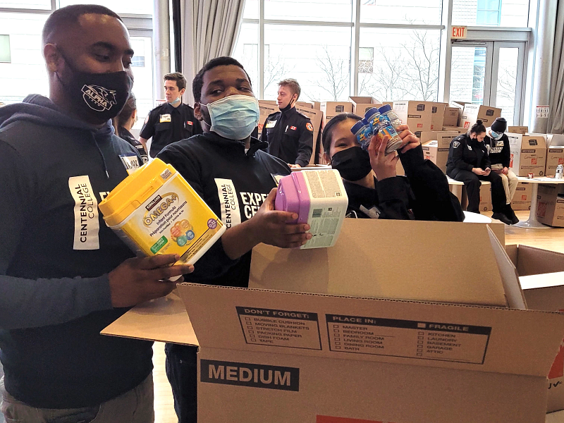 students packing up food and emergency supplies into cardboard boxes
