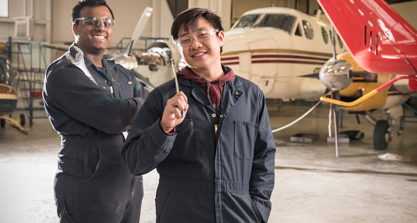 Picture of two male aviation students in front of an aircraft