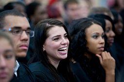 Female HYPE student laughing in a group with other students around her.