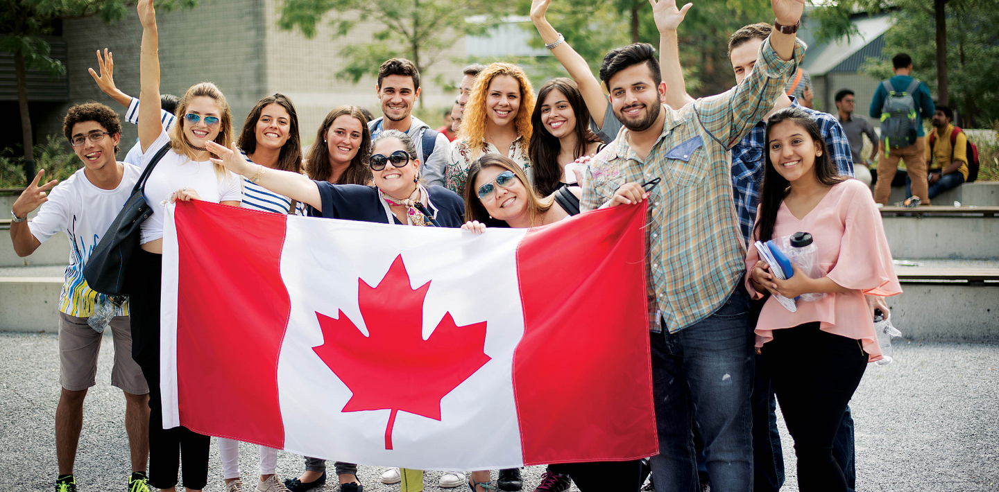 picture of Centennial College International Students holding a Canadian Flag smiling