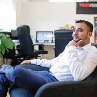 Picture of Centennial College Business Administration Marketing program graduate and CEO of TDot Performance Mubin Vaid sitting in a chair