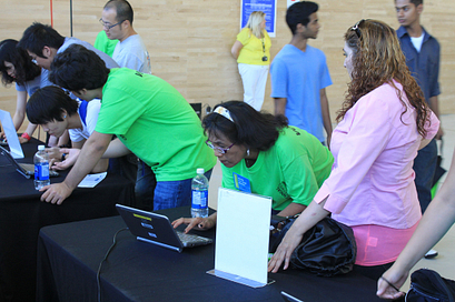 A Centennial College student ambassador looks up a new students information on a laptop during Centennial Welcomes 2012