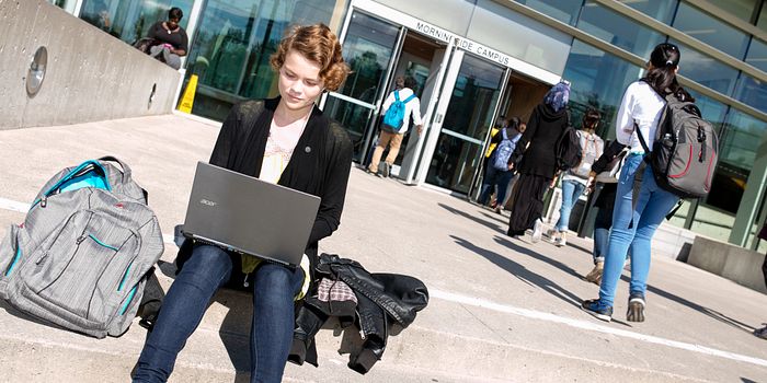 picture of a centennial college student sitting outside morningside campus updating their passwords