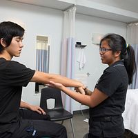 Picture of a Centennial College massage therapy student practicing on a patient