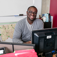 picture of Centennial College Social Service Worker program alumni Stephen Linton smiling and sitting in his City of Toronto office
